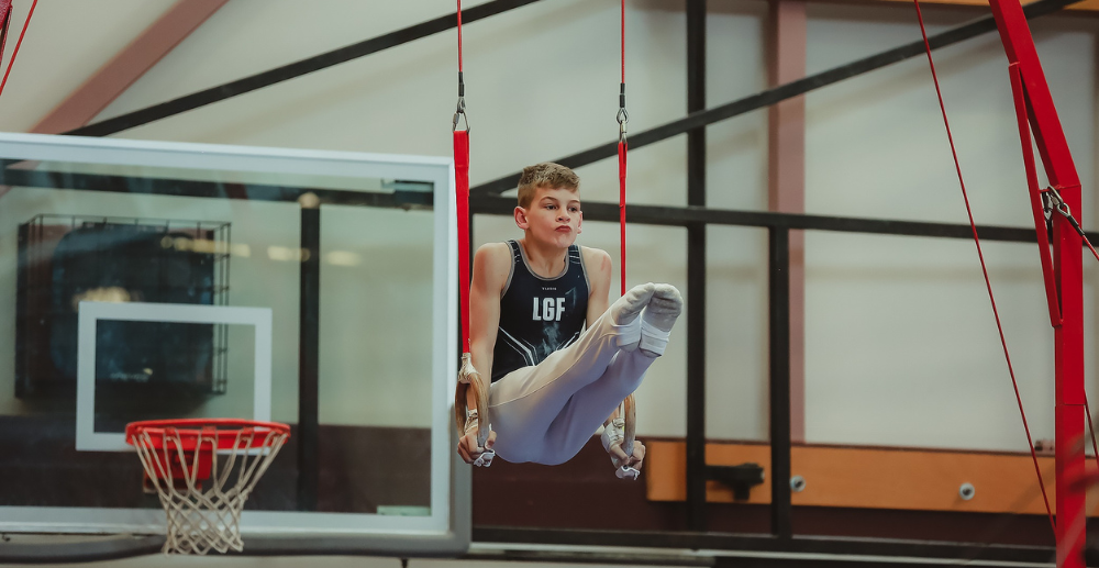 Young gymnastics competes on the rings at the BC Winter Games.
